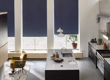 Modern kitchen with three tall windows, each with dark blue Luxaflex roller blinds